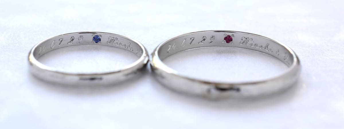 サファイアとルビーを一つずつ内側にナナコ留めでセッティングしている結婚指輪